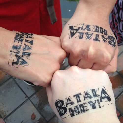 Hands with BATALA HEY tattooed on them