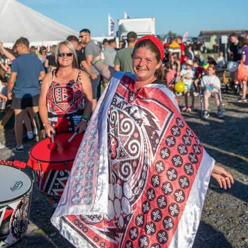 Girl smiling at camera wearing white and red silk tabard