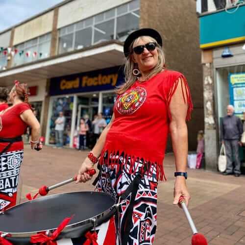 Female drummer with large drum smiling